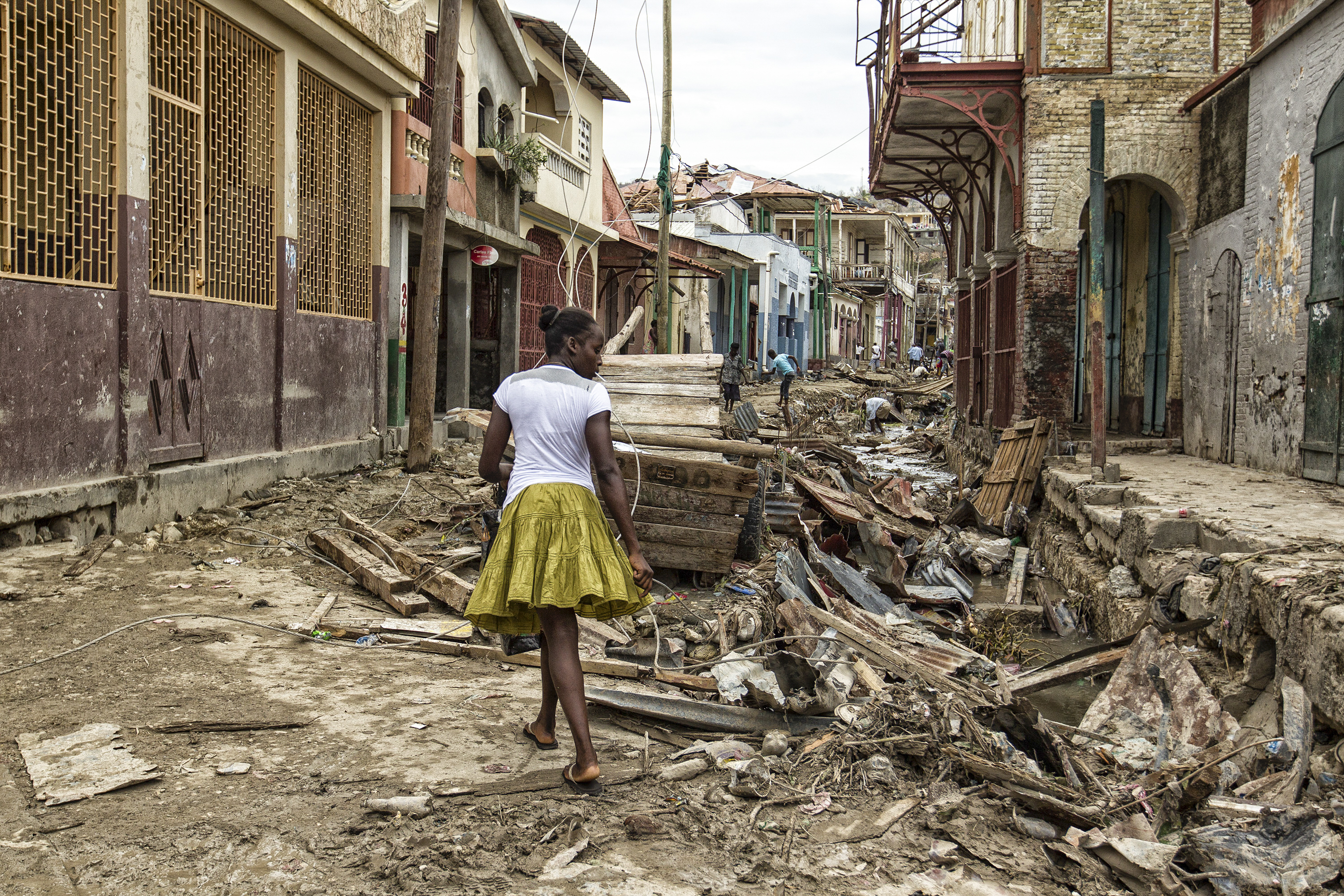 A person standing on a street destroyed by a hurricane