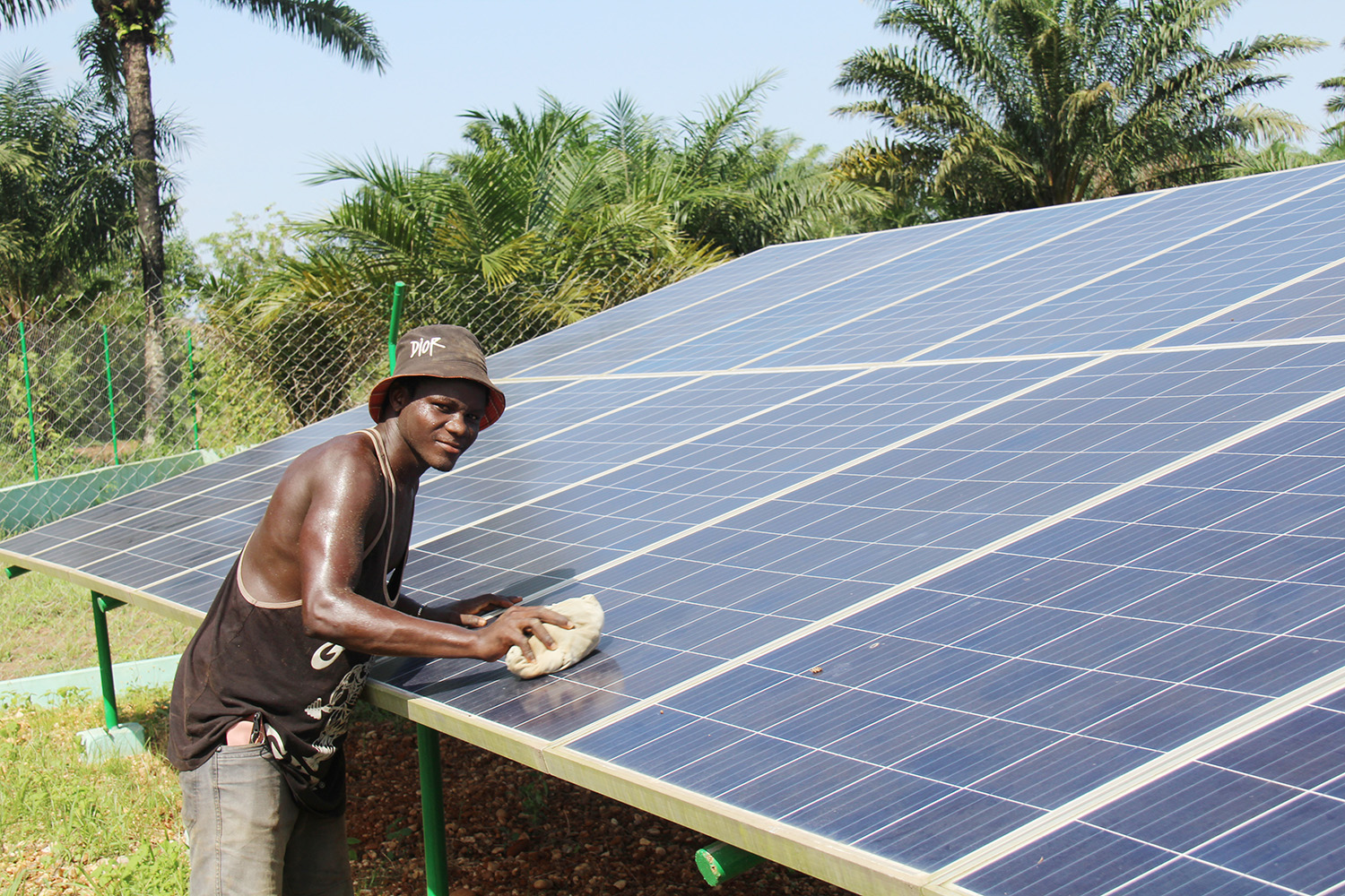 Un homme en train de nettoyer un panneau solaire