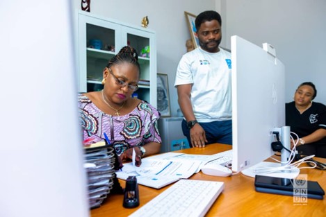 un groupe de personnes assises à un bureau avec un ordinateur portable