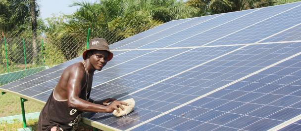 Un homme en train de nettoyer un panneau solaire