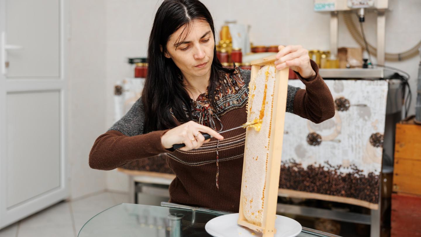 a woman holding a piece of cake on a table